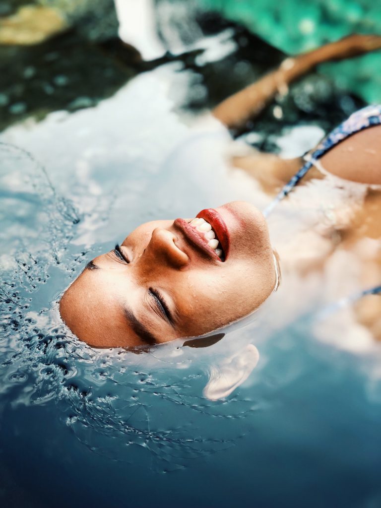 Sentirse bien (mujer sonriente sobre el agua)