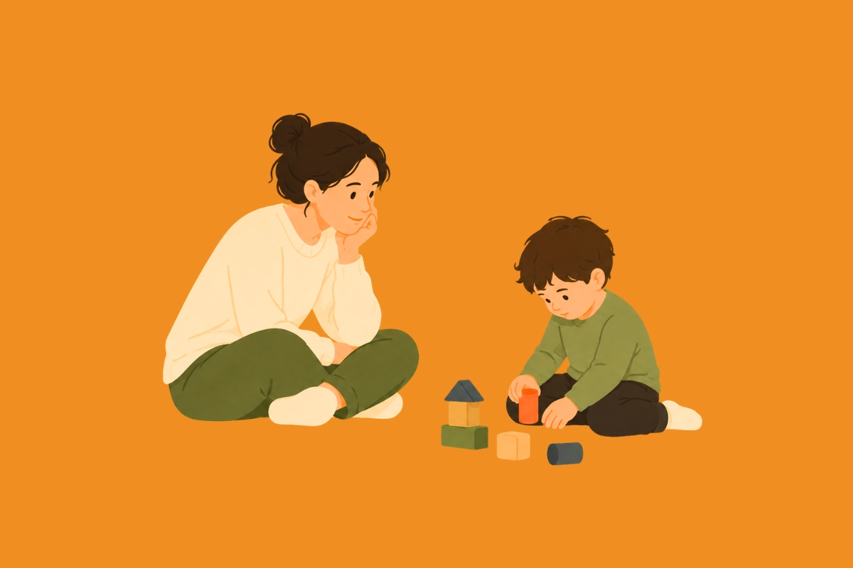 Adulto observando y acompañando a un niño jugando como representación de las señales tempranas del autismo